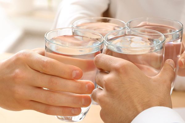 People drinking water in office, closeup